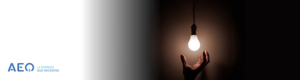 Mano alcanzando bombilla de luz para un texto sobre ahorro de luz.